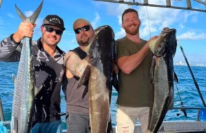 Mates showing off their fresh catch during a bucks party fishing trip Gold Coast