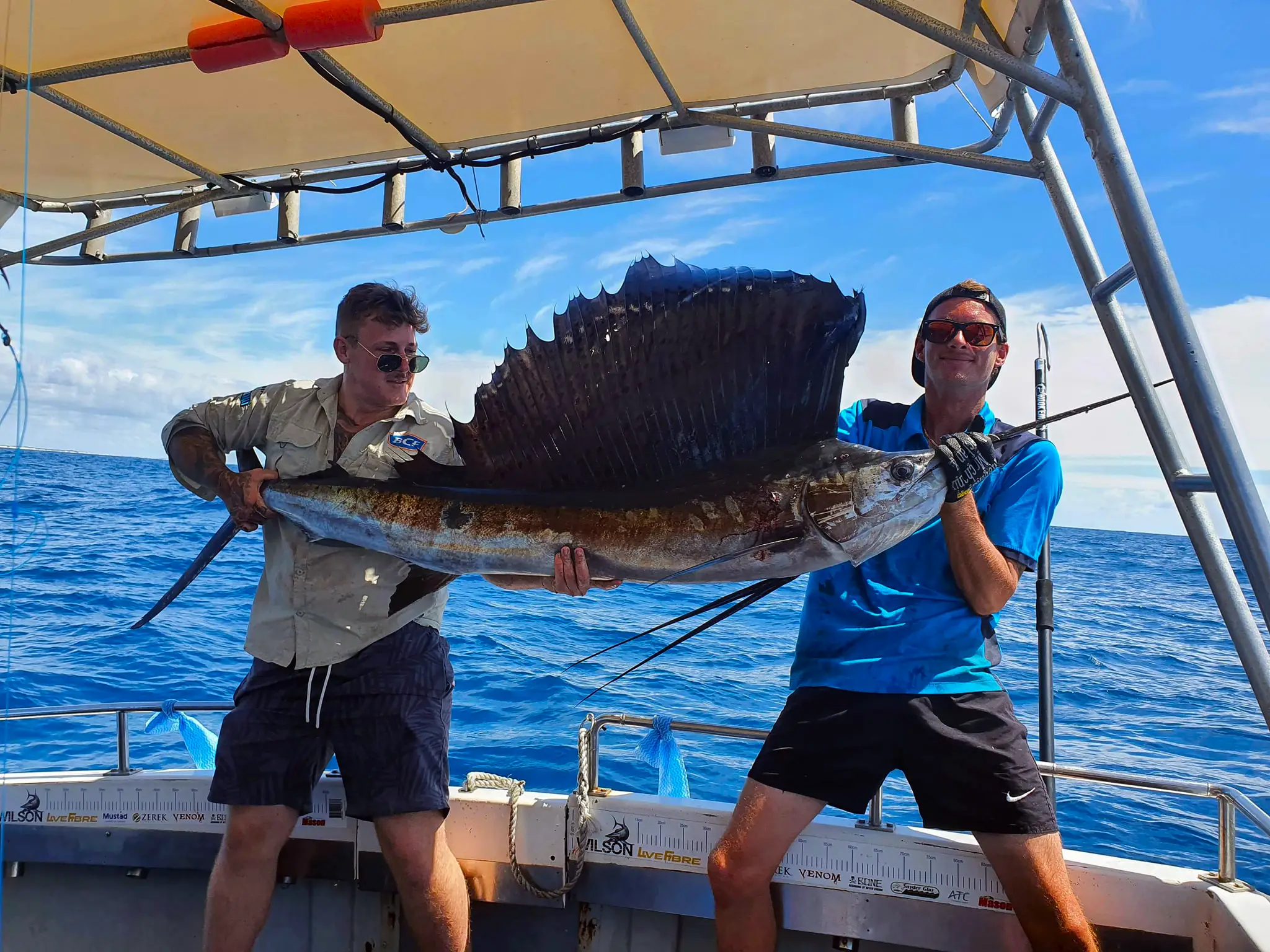 Happy guests holding their catch on a True Blue Fishing Charters Gold Coast trip