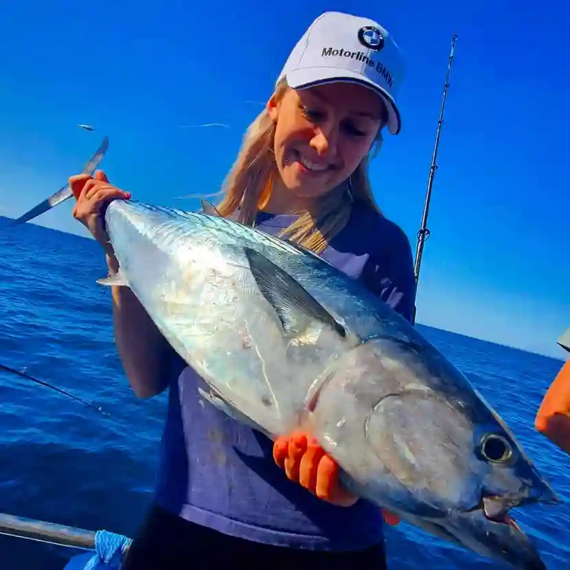 Angler holding a fresh catch on a full-day deep sea trip with True Blue Fishing.