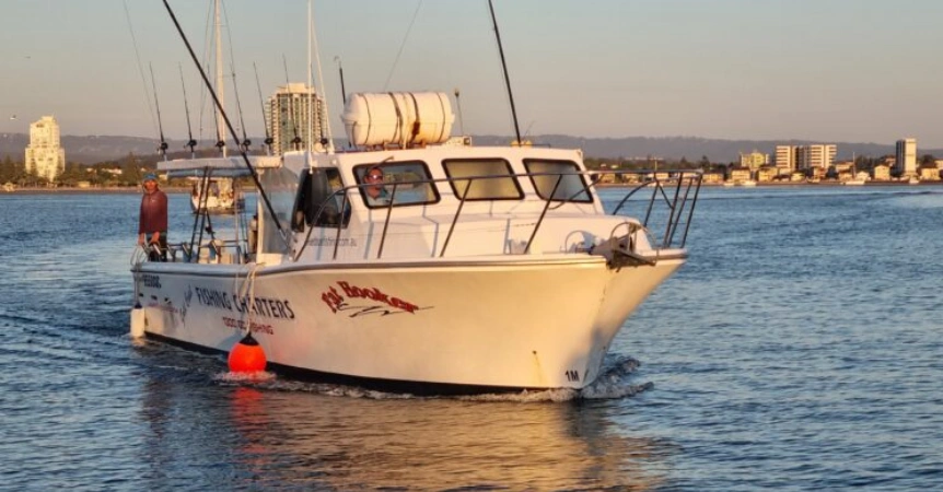 Angler holding a freshly caught fish aboard a half-day fishing charter with True Blue Fishing on the Gold Coast