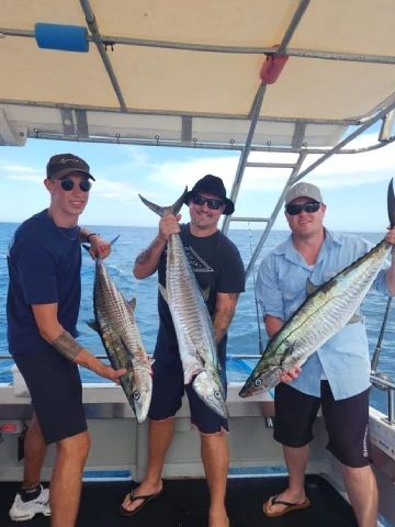 Friends celebrating a private fishing trip aboard True Blue Fishing Charters vessel